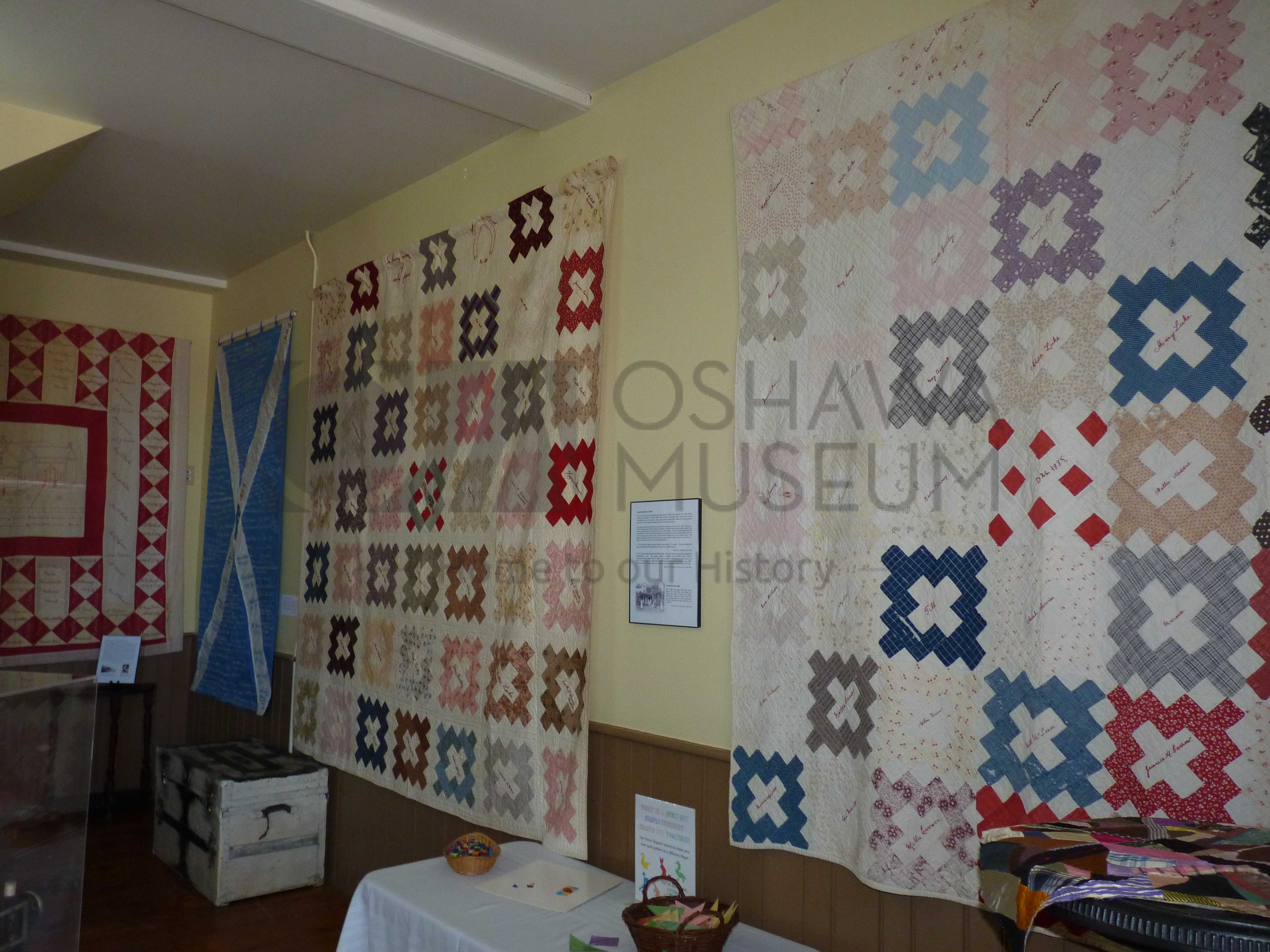 A room with colourful quilts handing on the walls